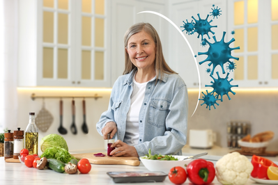 smiling older woman cooking with immunity boosting foods with illustrated shield protecting her from viruses