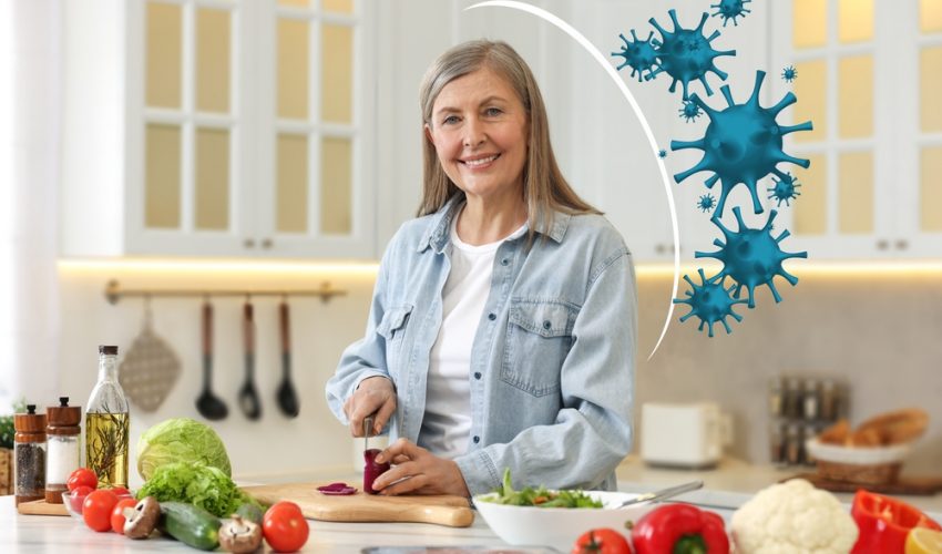 smiling older woman cooking with immunity boosting foods with illustrated shield protecting her from viruses