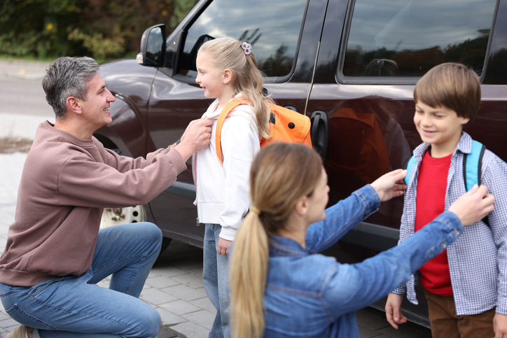 Parents helping kids with backpacks before school. Back to school immune boosters for busy families support their health and wellness.